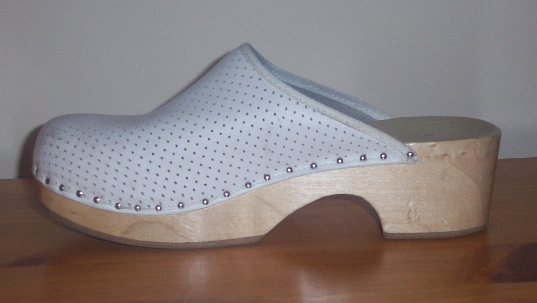 Wooden clog, with white, leather overhead.